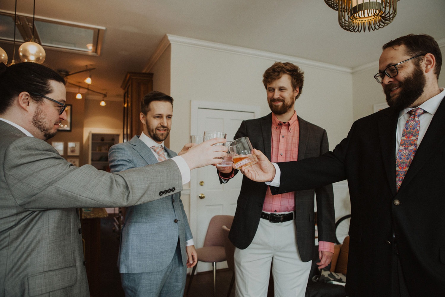 Groomsmen cheers while getting ready as part of wedding photography packages