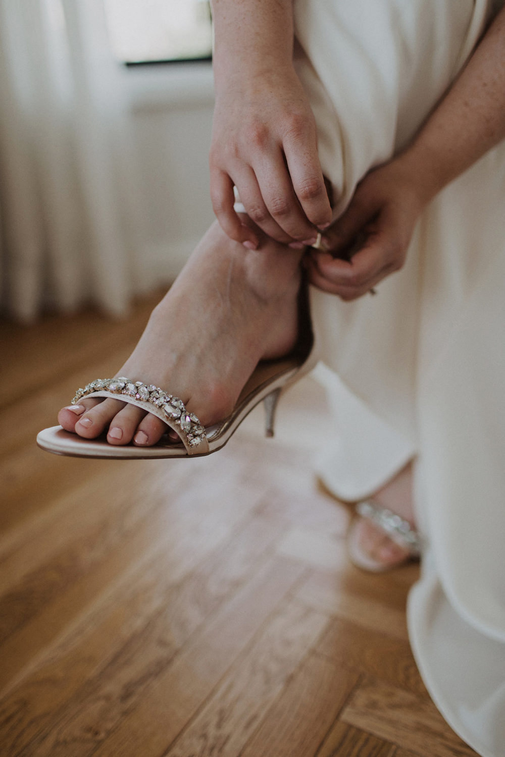 Bride puts on bejeweled wedding shoes