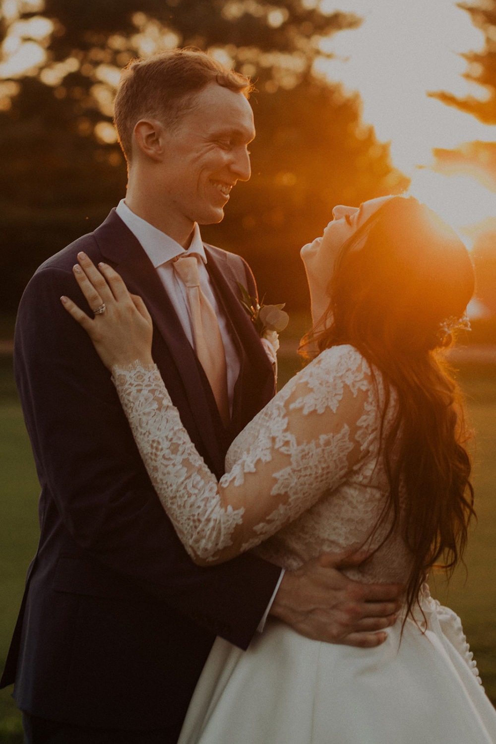 Couple embraces during sunset wedding photos
