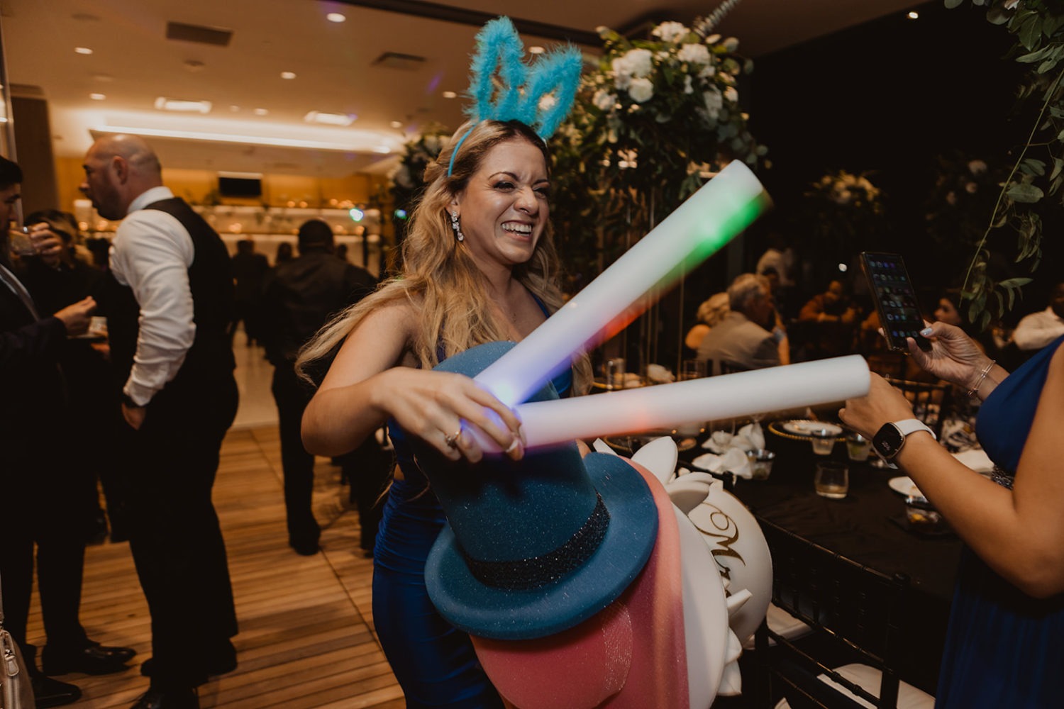 guest hands out glow sticks and hats at wedding reception dance party