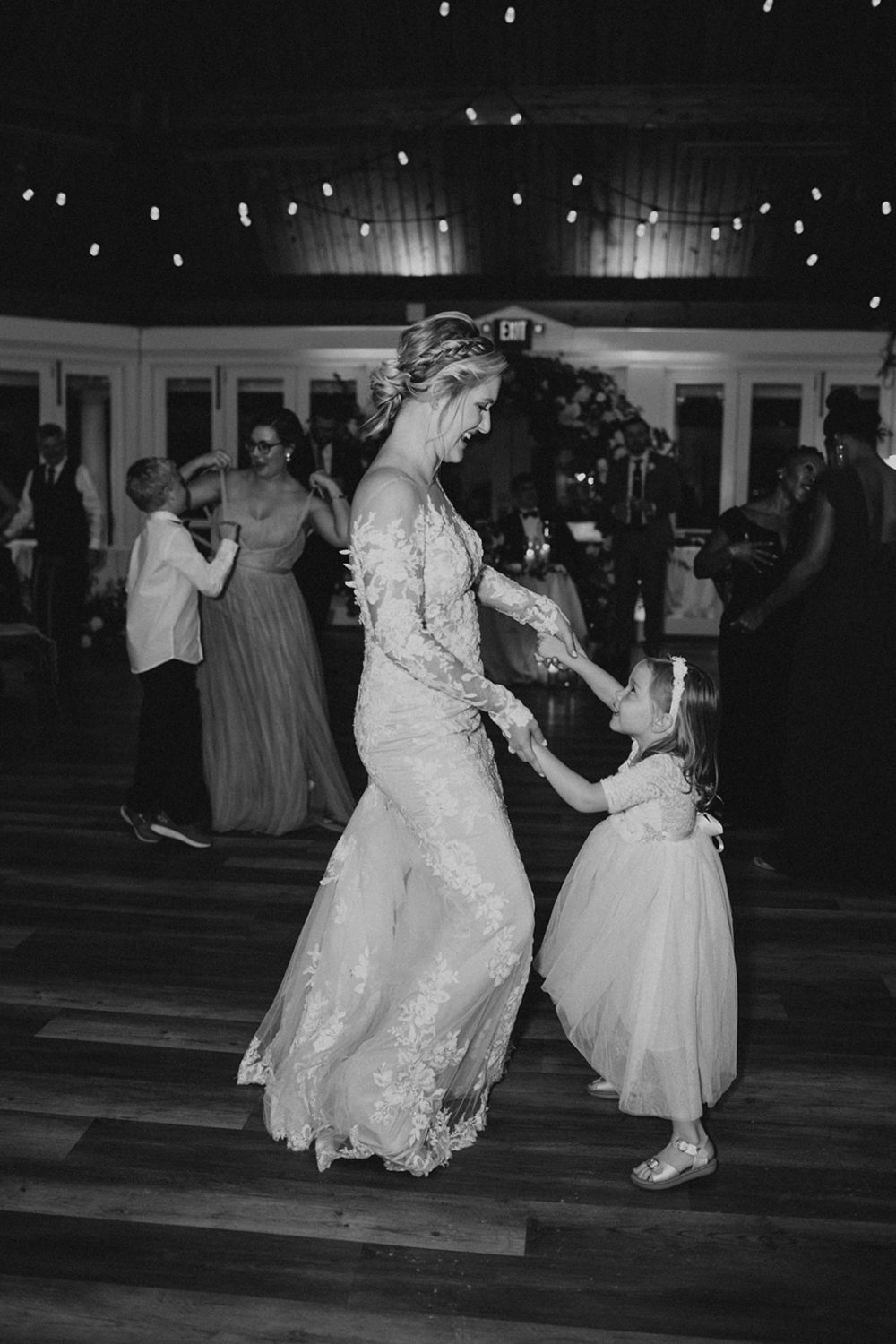 bride dances with flower girl during wedding reception