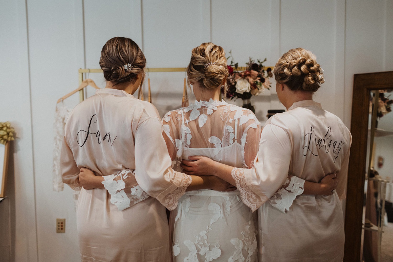 bride stands with bridesmaids in silk robes