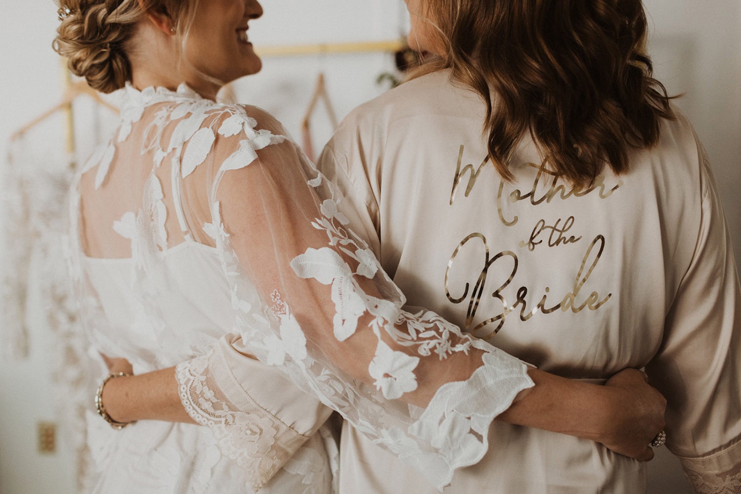 bride stands with mom in silk robes