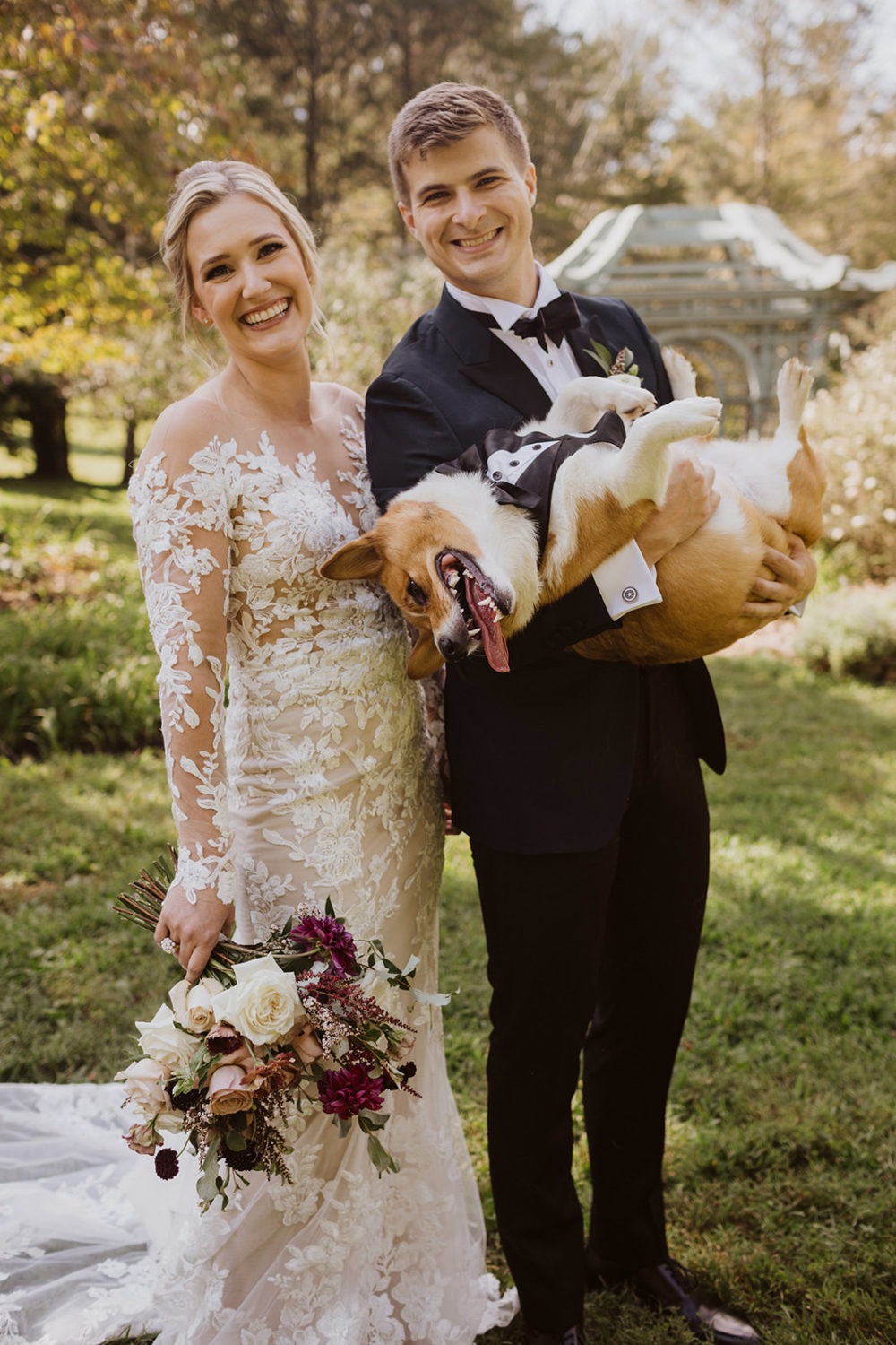 couple holds dog during wedding first look