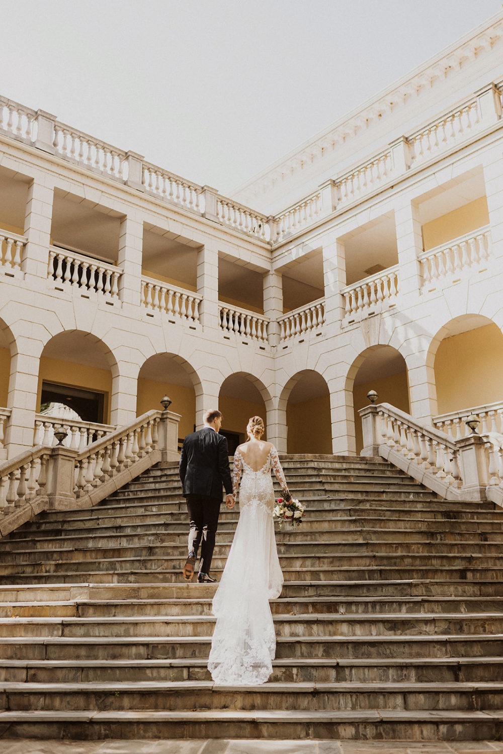 Couple kisses walks up staircase at Airlie Warrenton, VA wedding venue 