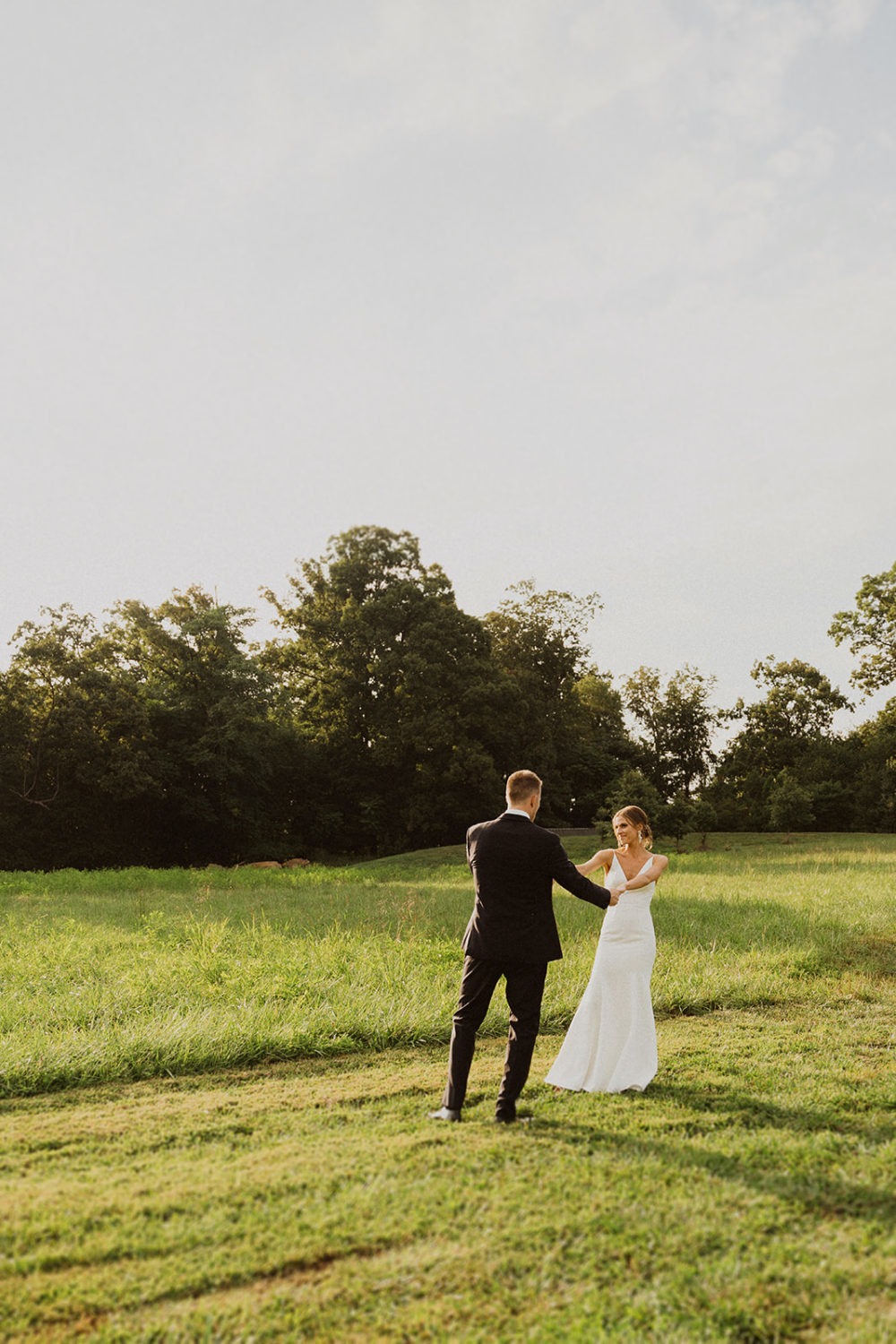 Couple walks through sunset field at Glen Ellen Farm wedding