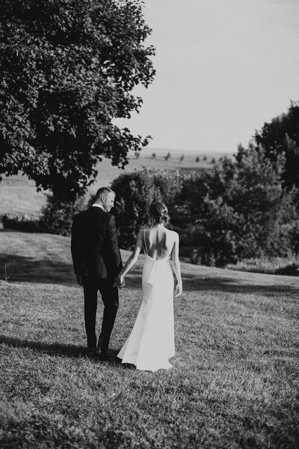Couple walks through sunset field at Glen Ellen Farm wedding