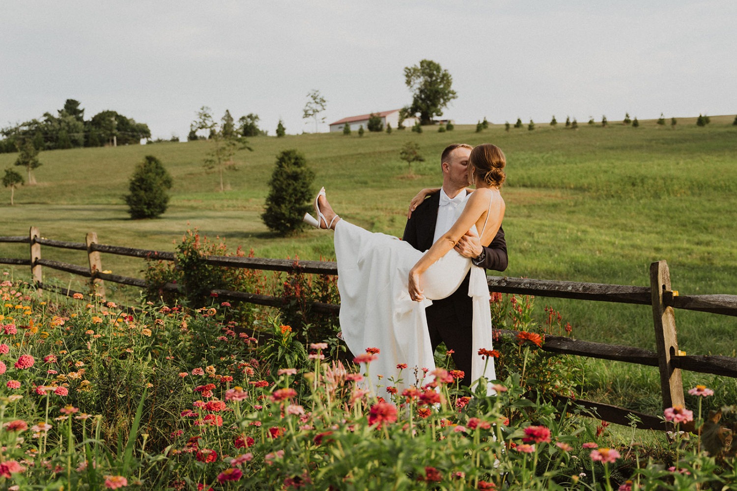 Couple walks kisses in wildflower field at Glen Ellen Farms wedding