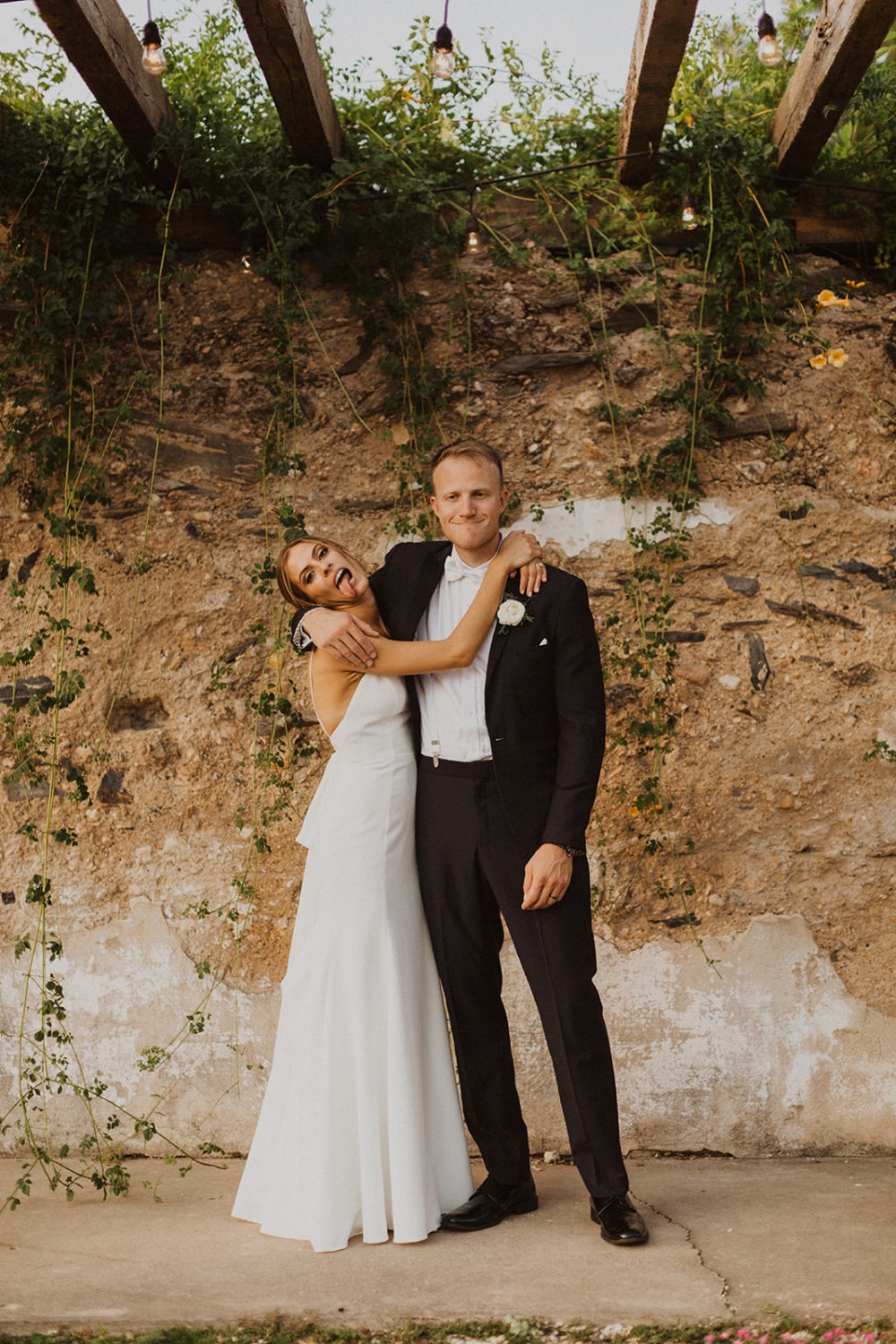 couple embraces in front of stone barn ruins