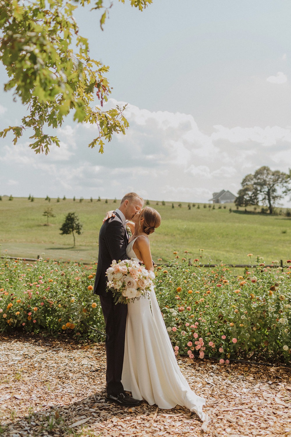 Couple kisses in wildflower garden at Glen Ellen Farm wedding