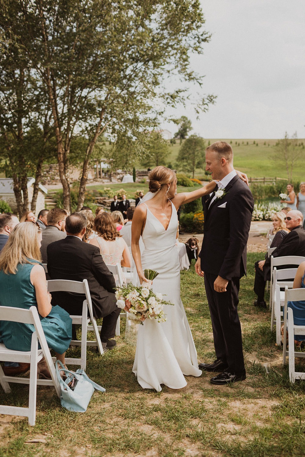 Couple looks back at dog during wedding ceremony
