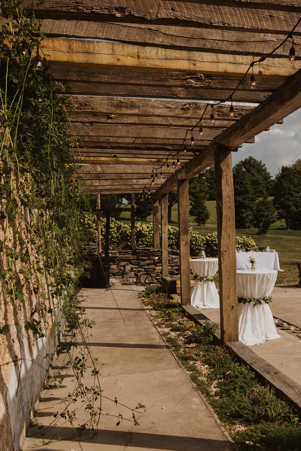 cocktail hour tables set up beside ivy-covered barn ruins