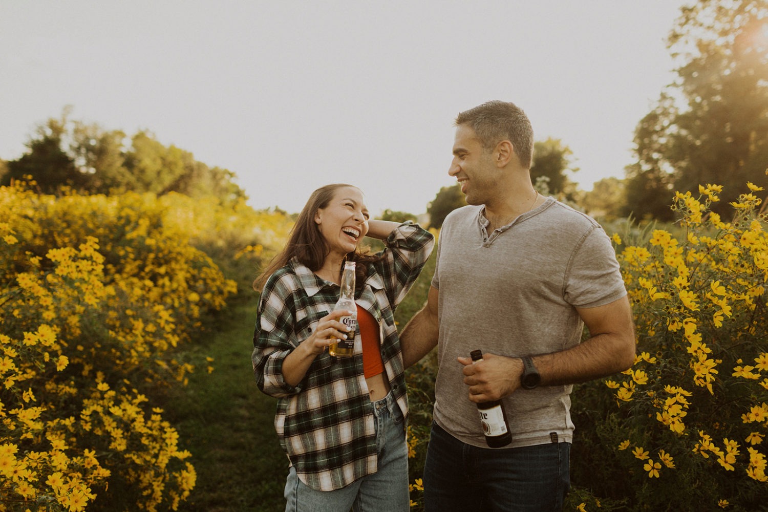 couple drinks beer at wildflower field engagement session