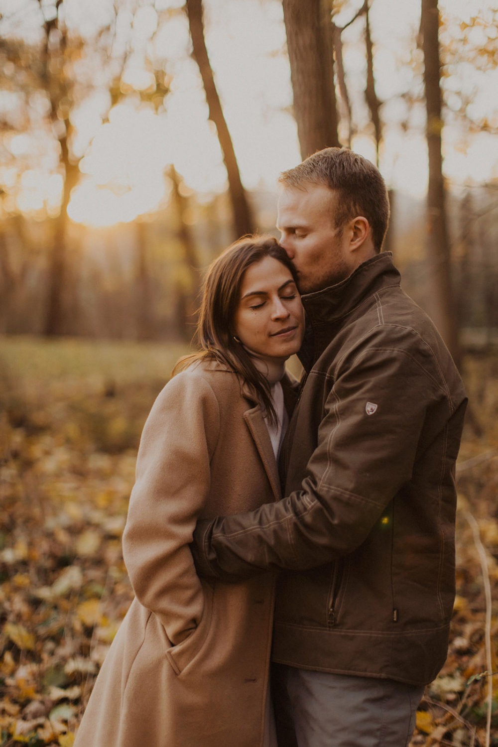 couple kisses at fall engagement photos session