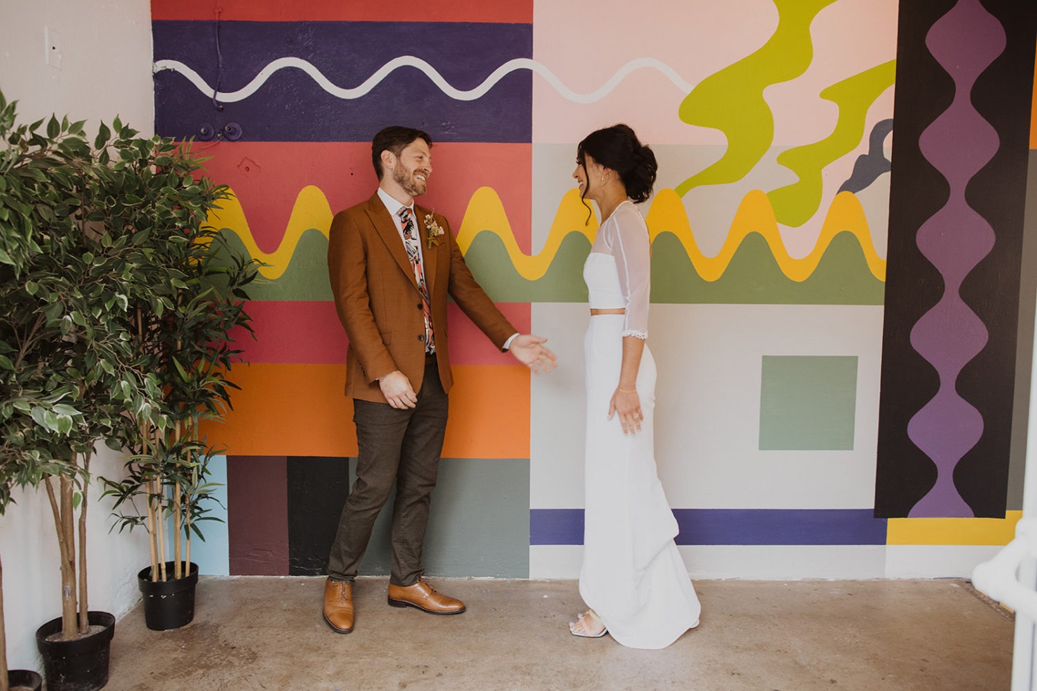 couple has first look in front of colorful wall at Culture House DC wedding venue