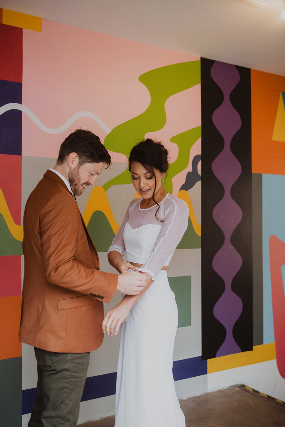 couple has first look in front of colorful wall at Culture House DC wedding venue
