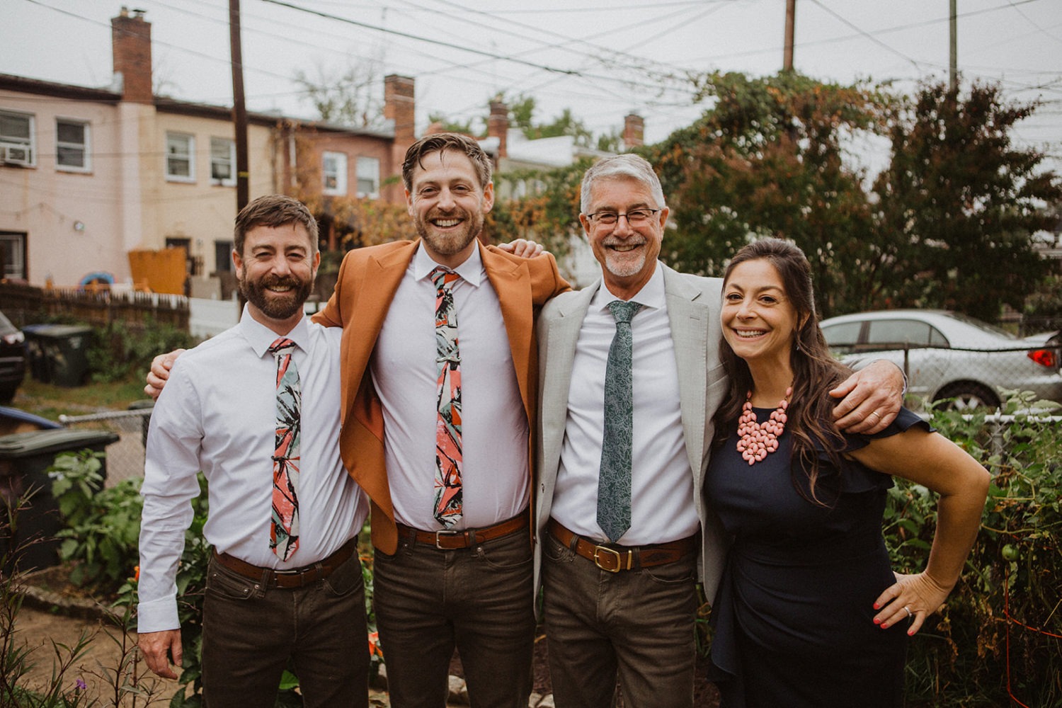groom stands with family wearing matching ties on wedding day