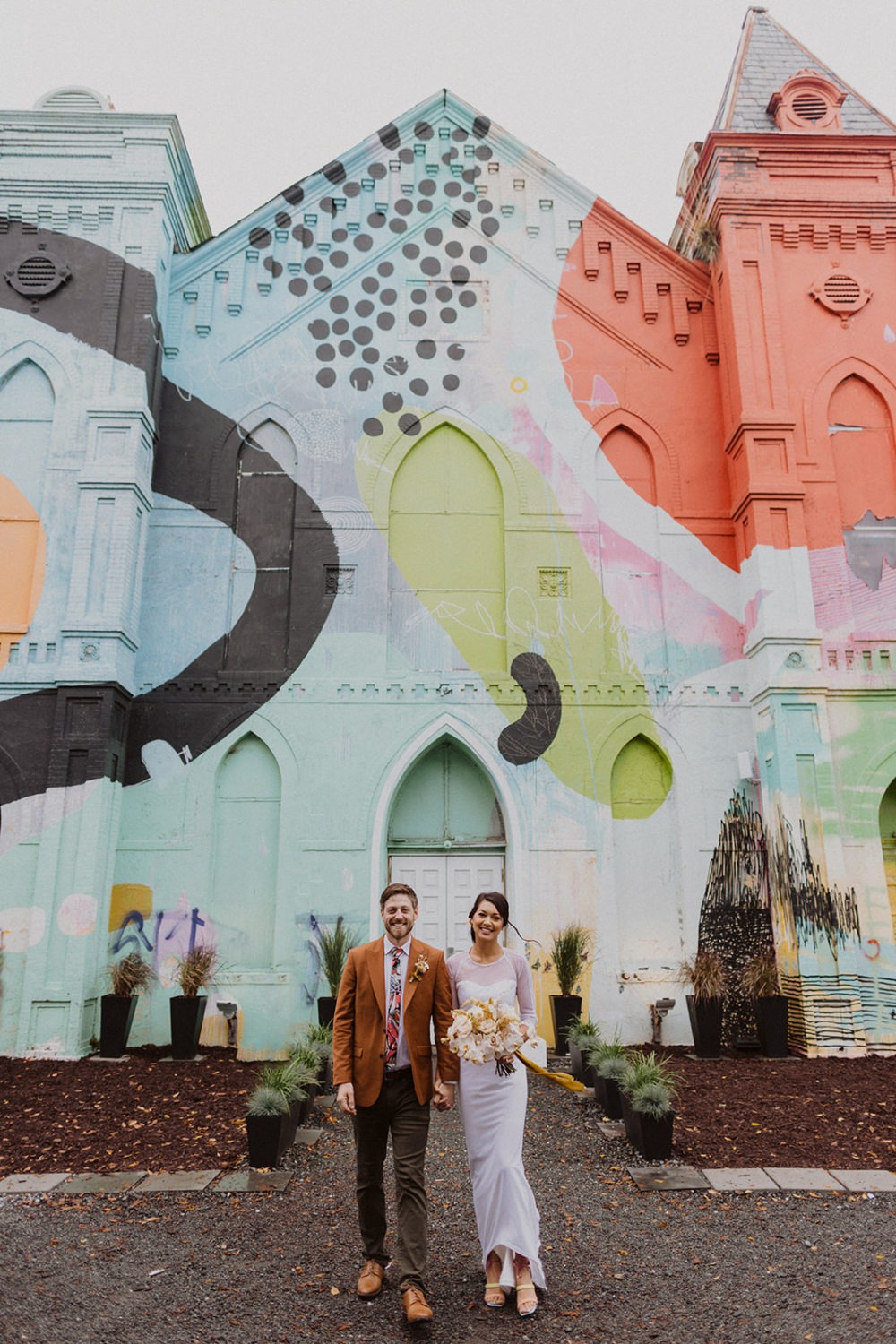 couple stands holding hands in front of Culture House DC wedding venue