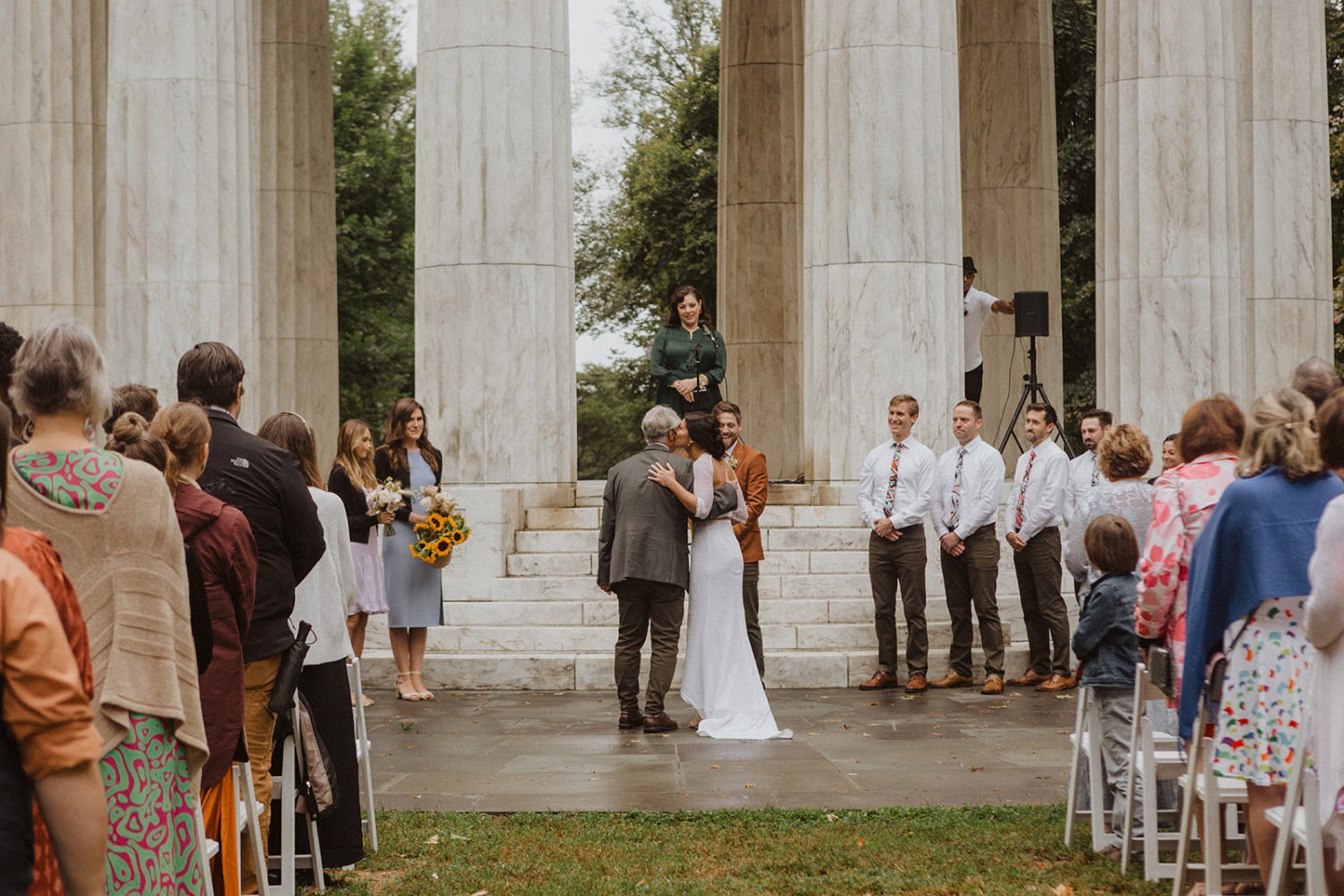 bride kisses dad on cheek during DC War Memorial wedding ceremony