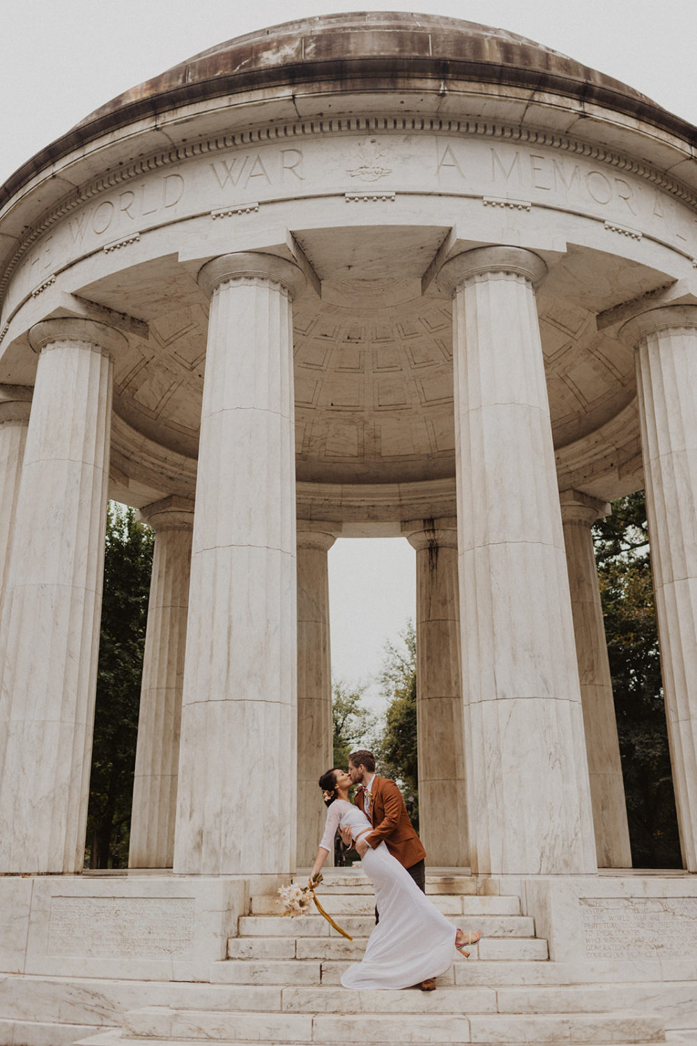 couple kisses in front of DC War Memorial wedding 