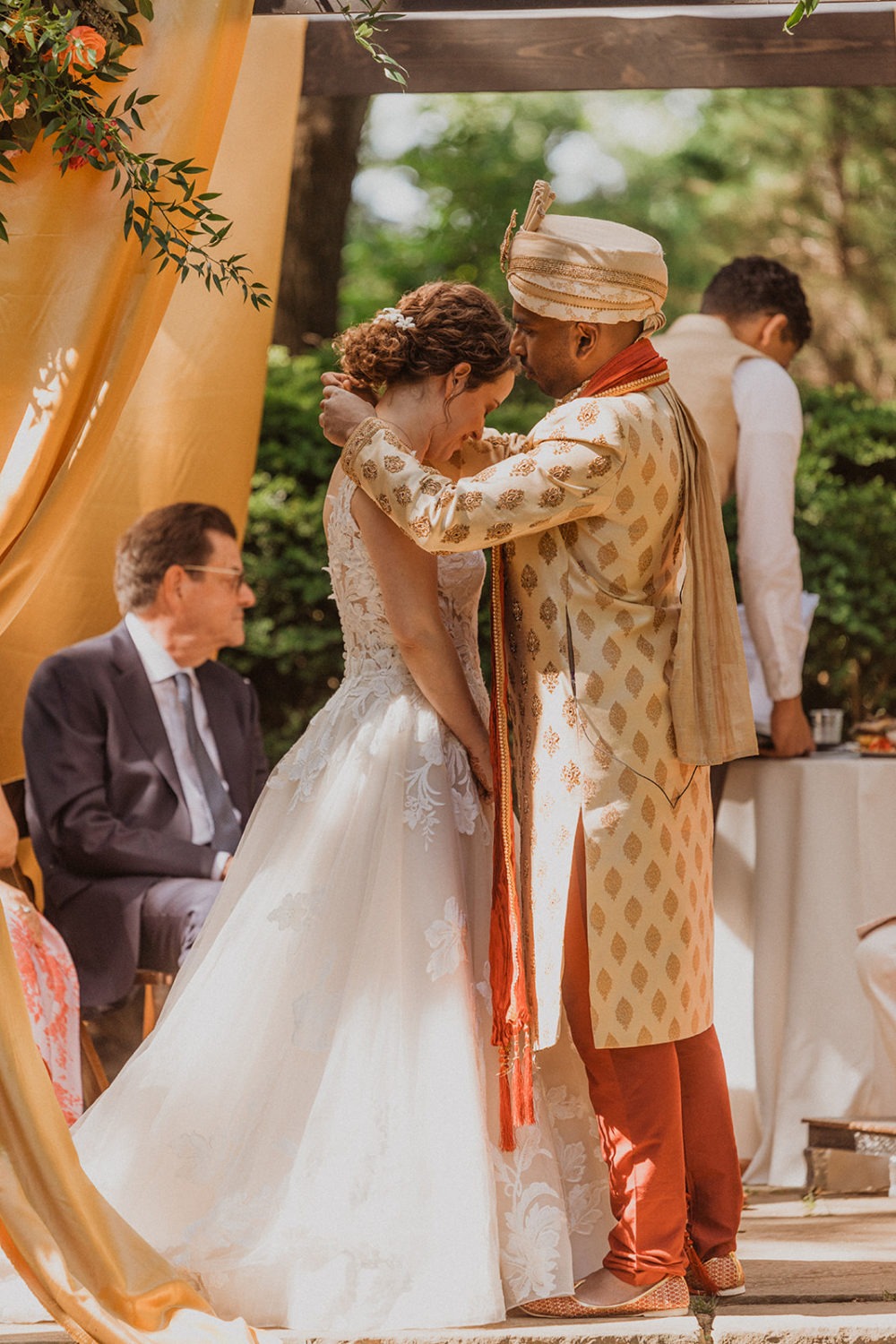groom wraps necklace around bride as part of hindu wedding traditions