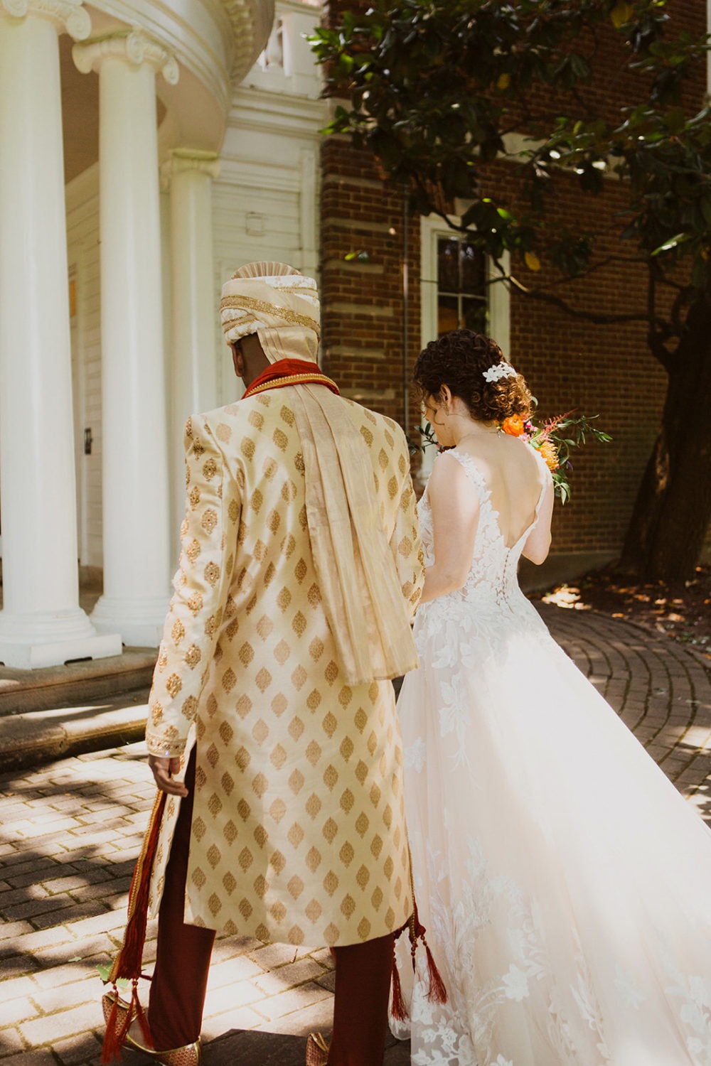 bride and groom walk holding hands at outdoor maryland wedding venue