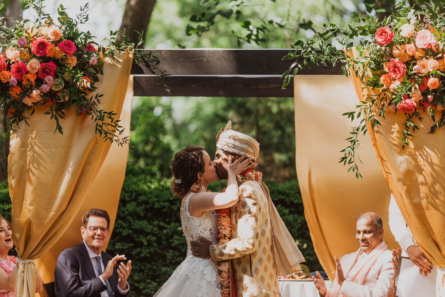 couple kisses under chuppah as part of jewish wedding traditions