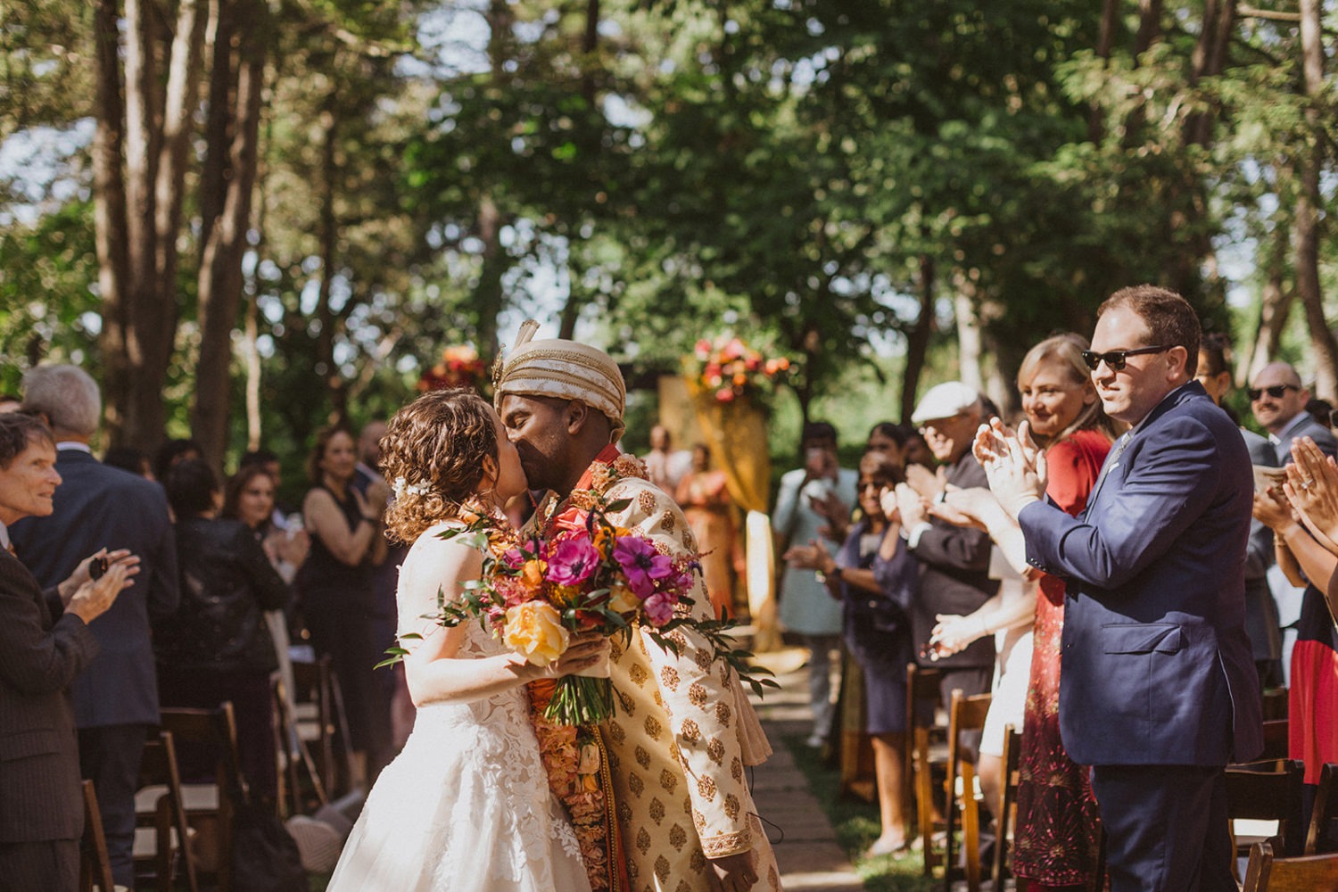 couple kisses while exiting wedding ceremony during as part of jewish wedding traditions