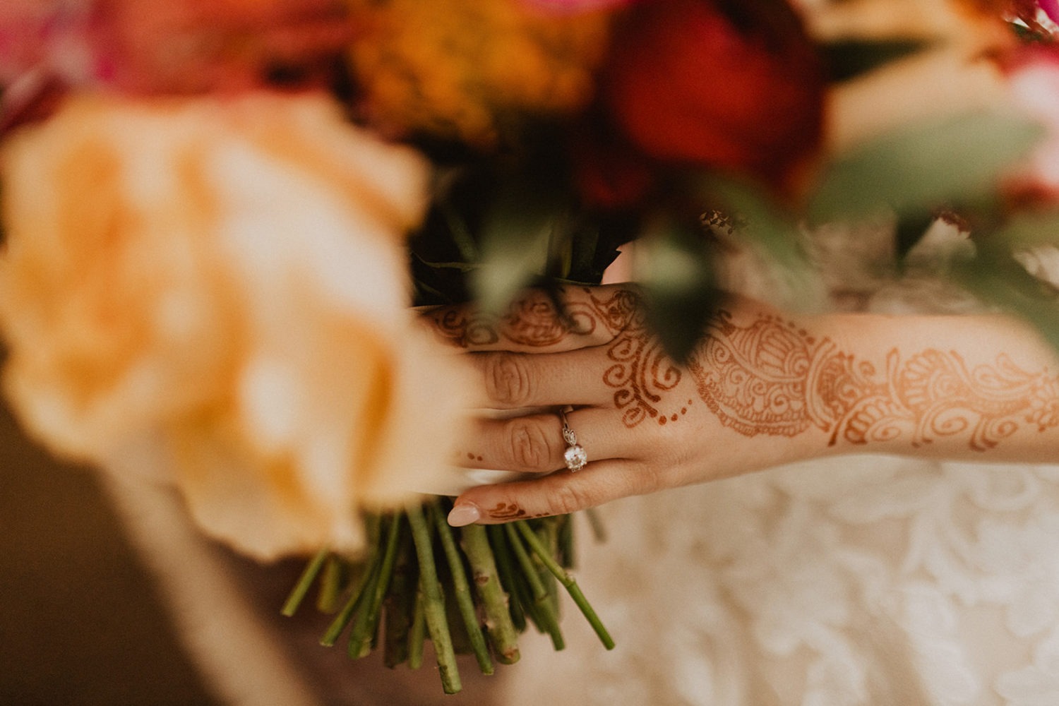 bride with henna on hands holding wedding bouquet