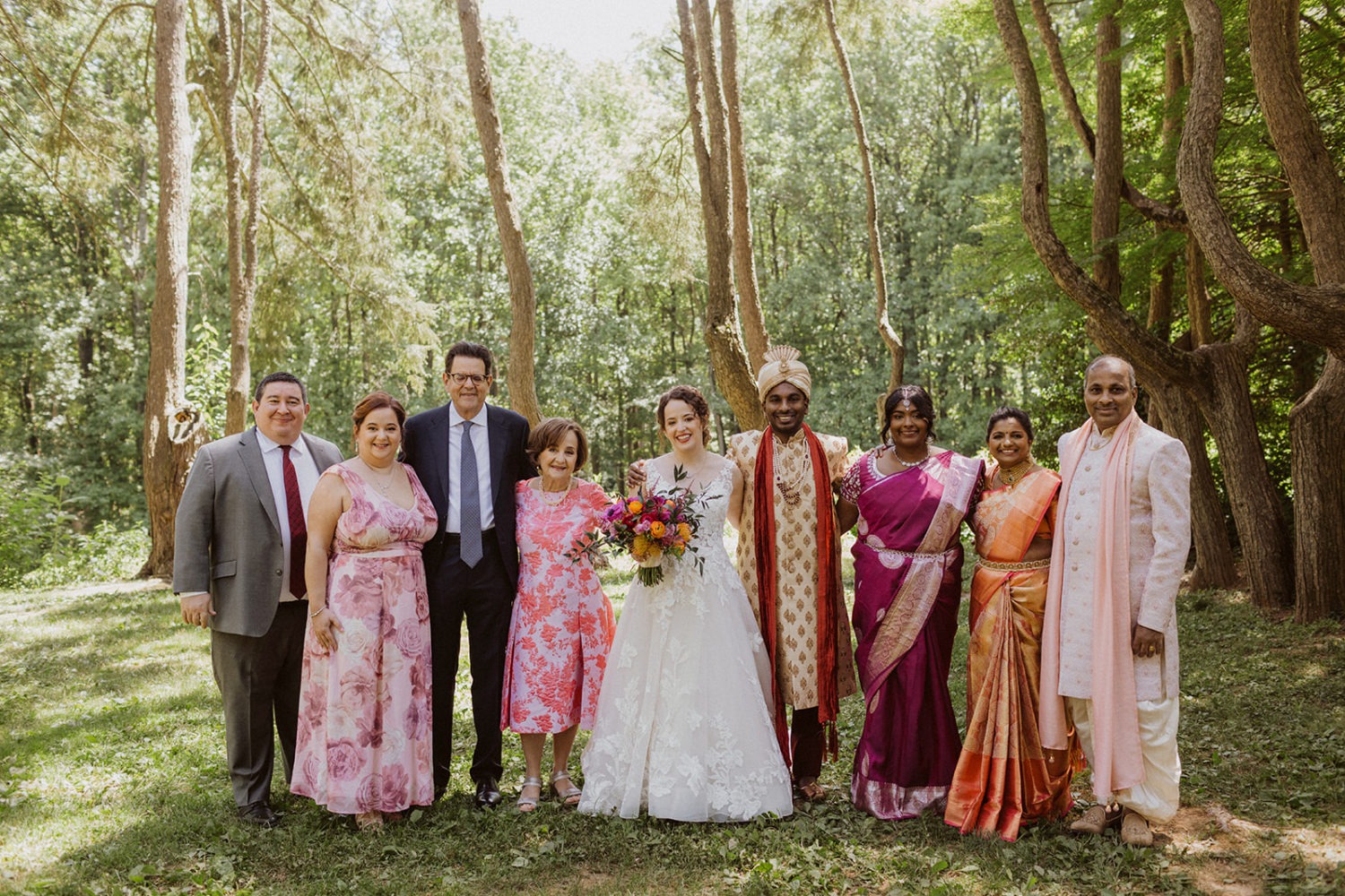 newlyweds stand with both sides of family in wedding photos
