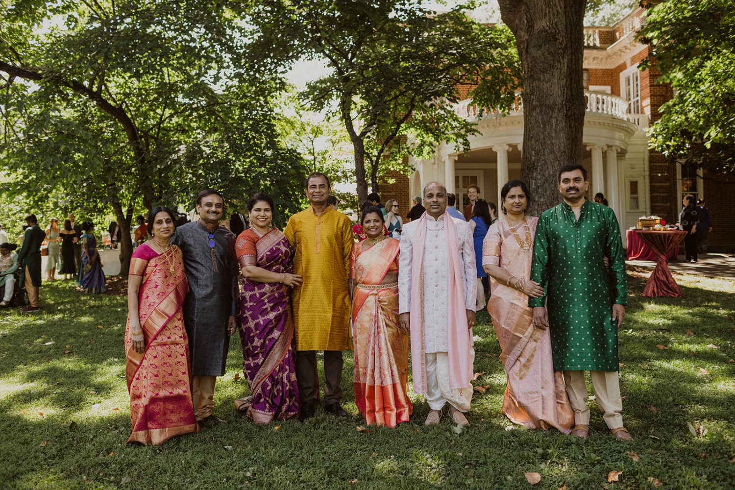 guest stand together wearing indian clothing at outdoor wedding