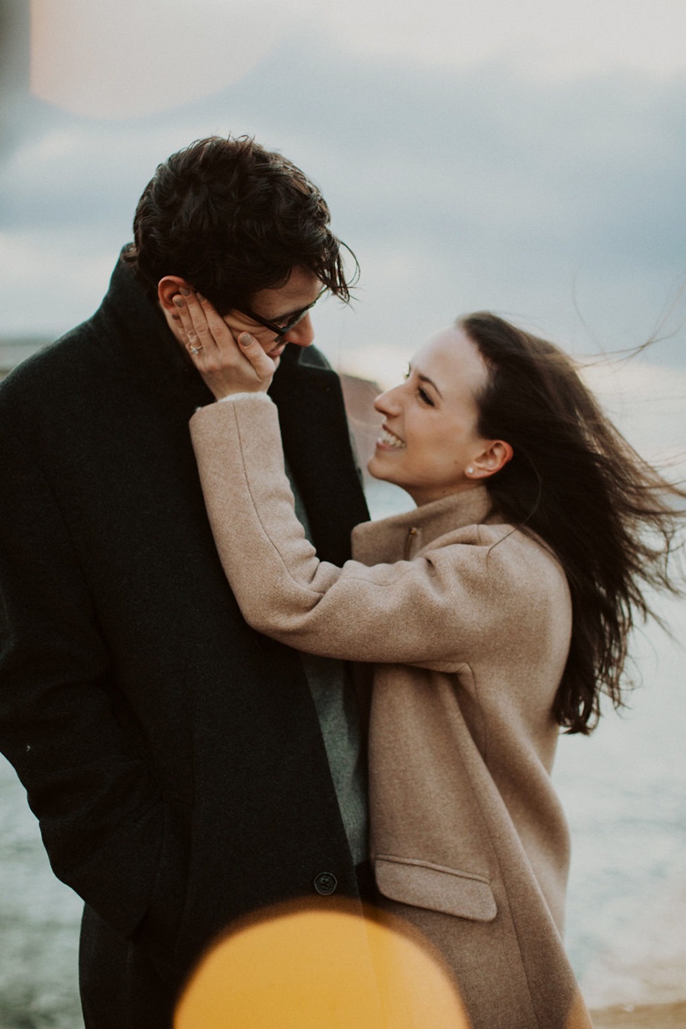 couple embraces at windy engagement session