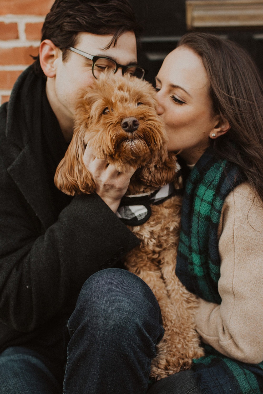 couple kisses dog at Baltimore winter engagement session