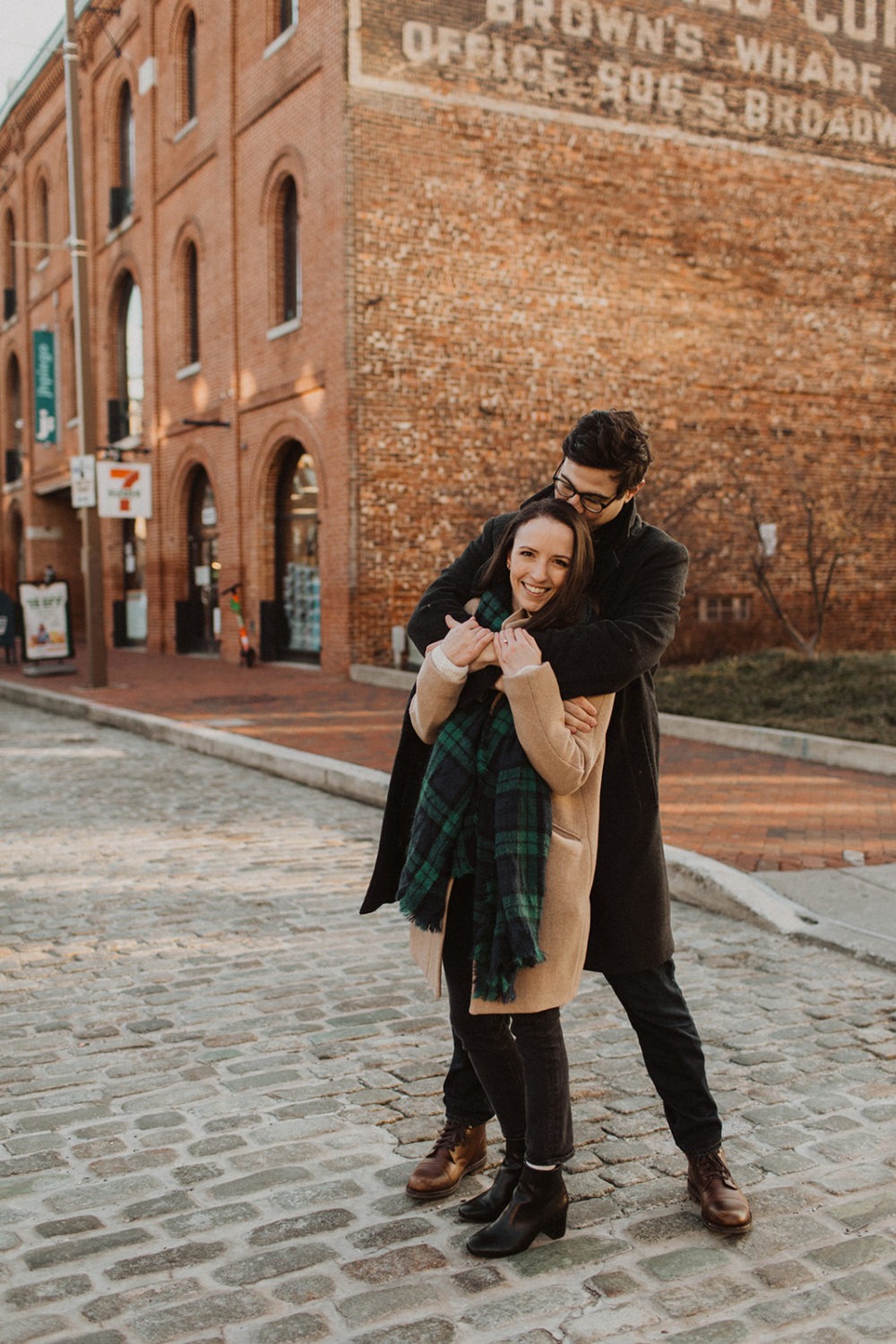 couple embraces at Baltimore windy winter engagement session