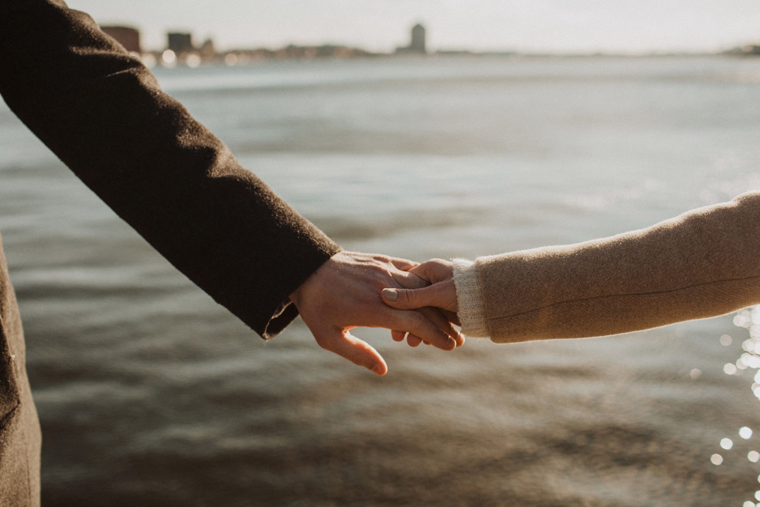 couple holds hands at Baltimore waterside engagement session