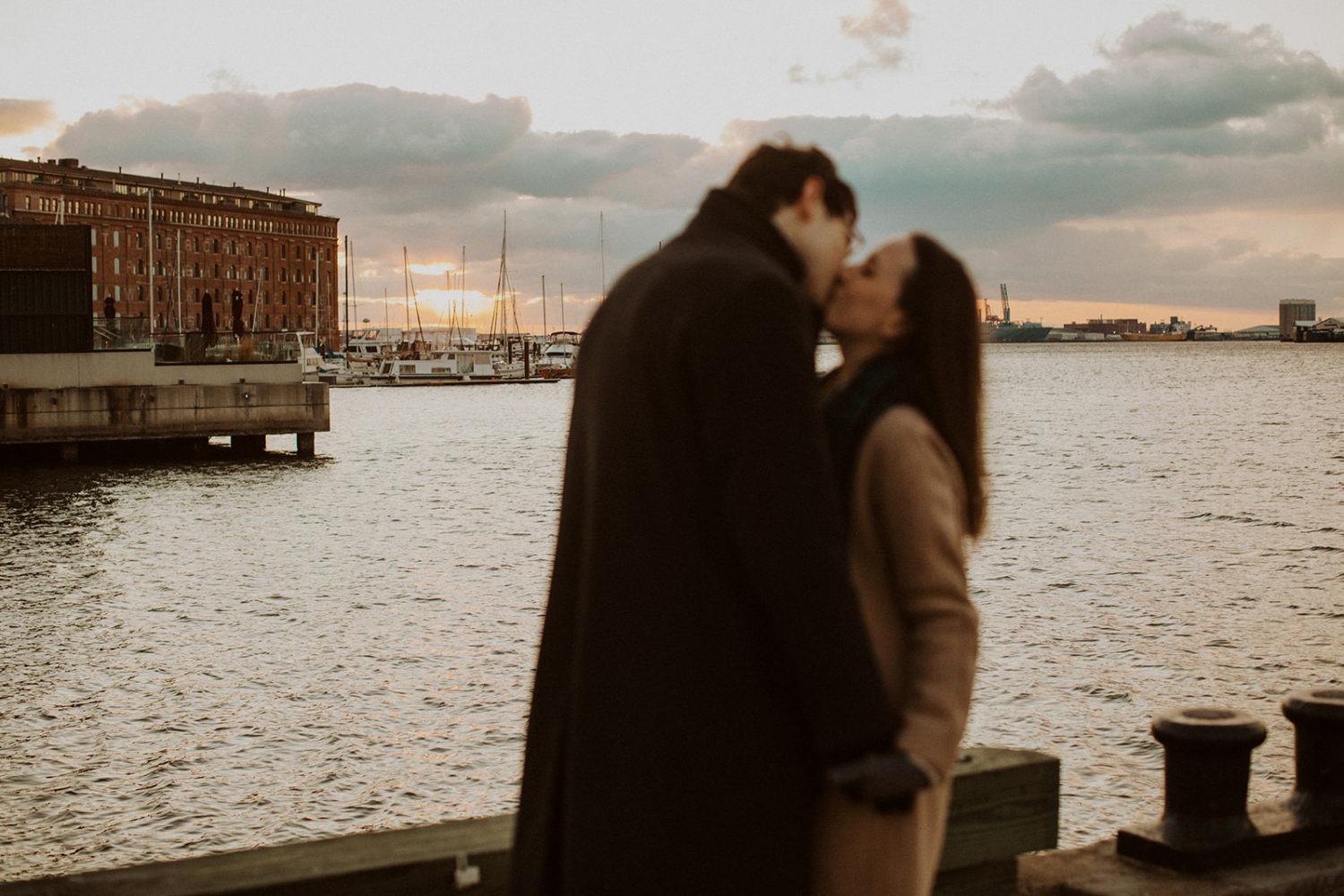 couple kisses during winter engagement photos in winter