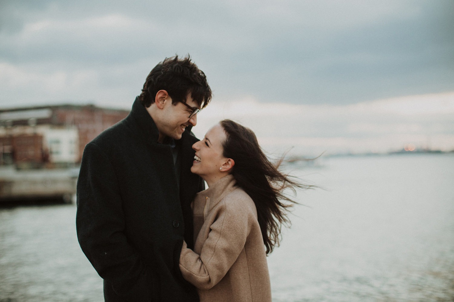 couple embraces at windy engagement session
