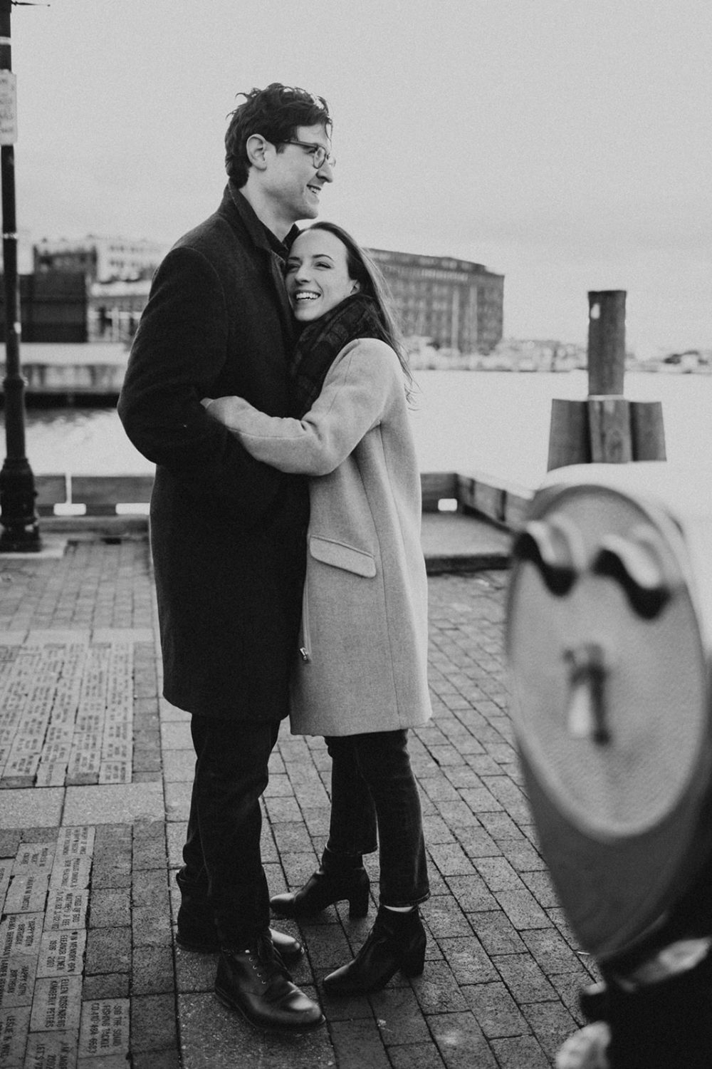 couple embraces at windy winter engagement session