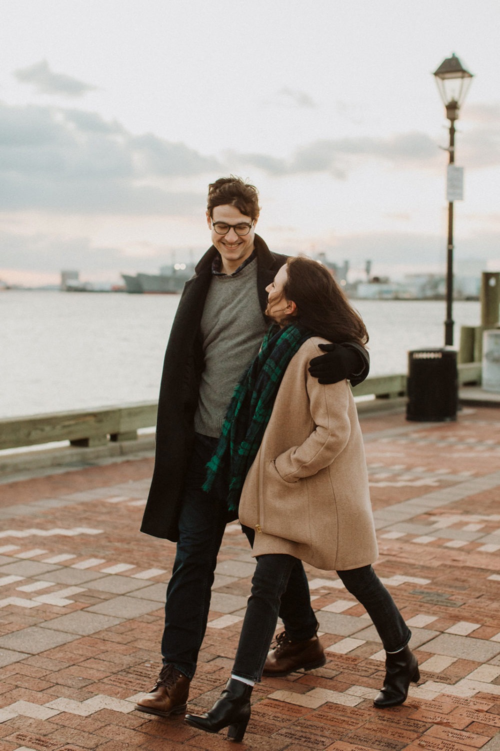 couple walks together at engagement photos in winter