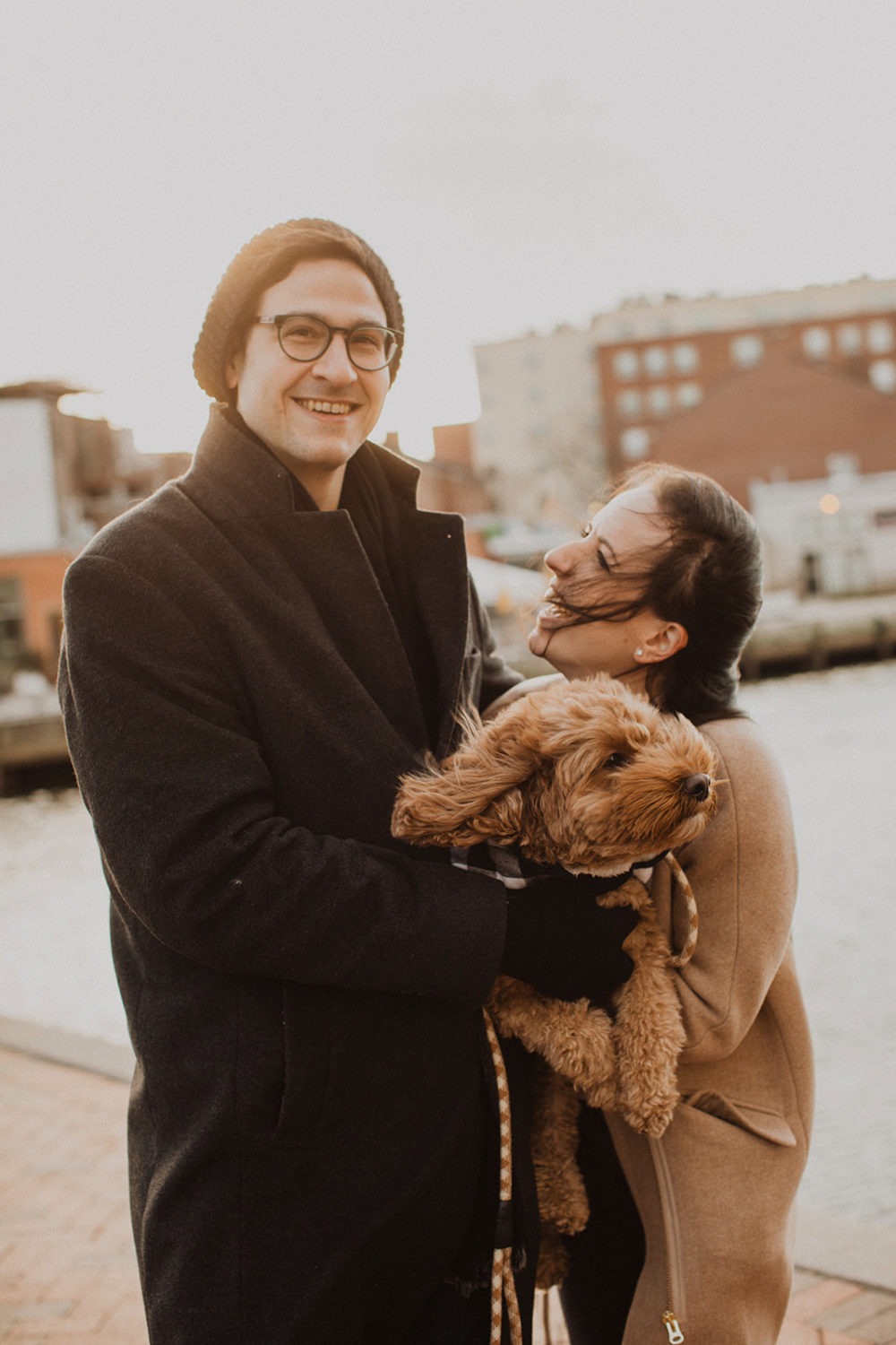 couple holds dog at engagement photos in winter session