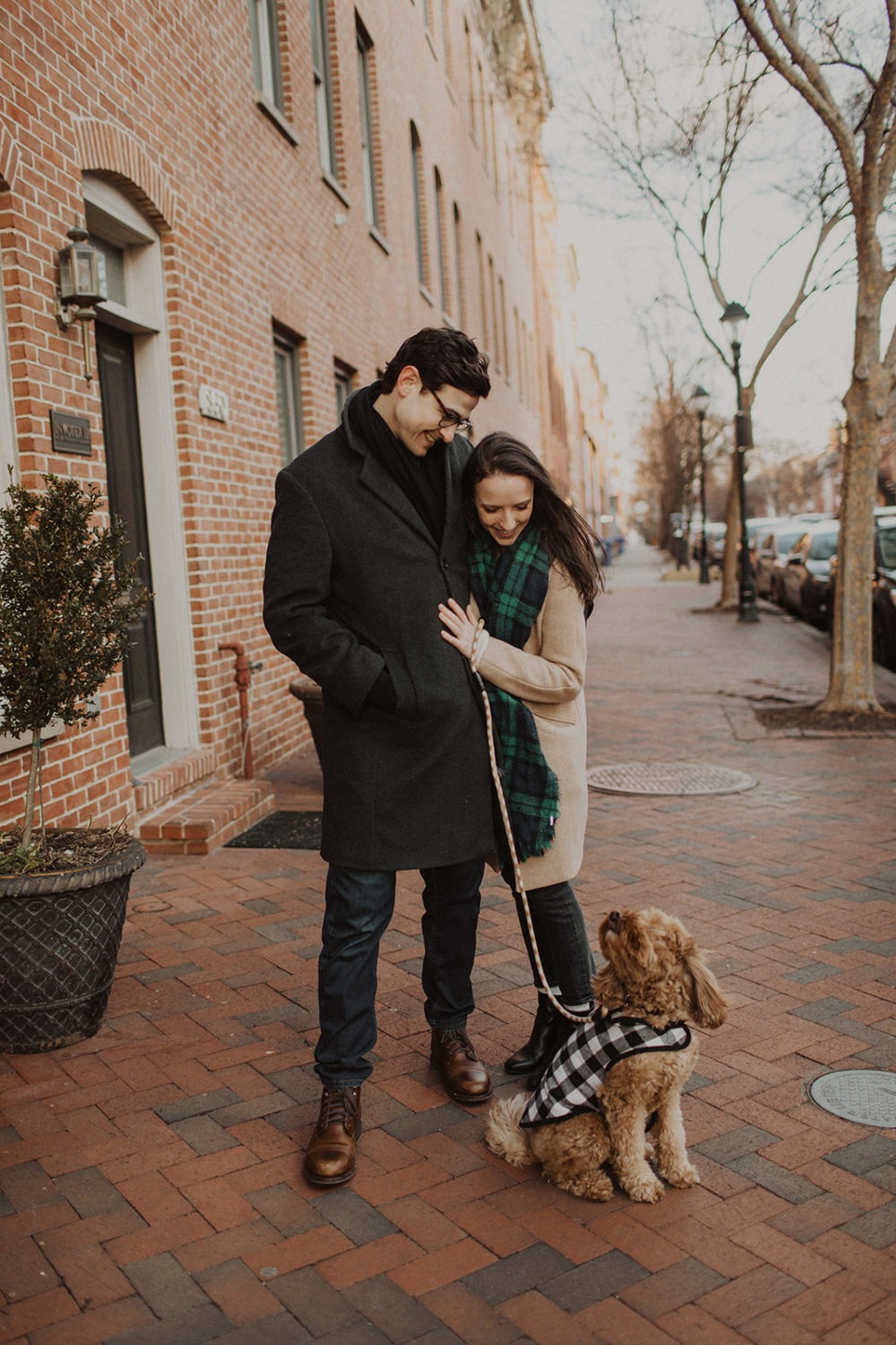 couple walks dog at engagement photos in winter session