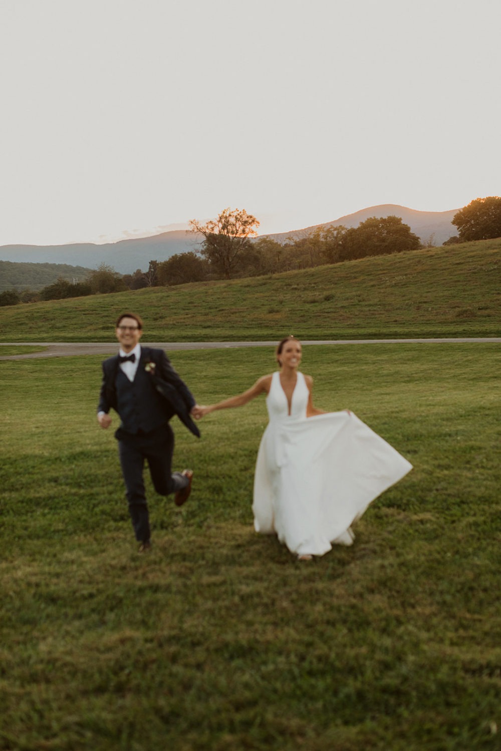 couple runs through field at sunset farm virginia wedding