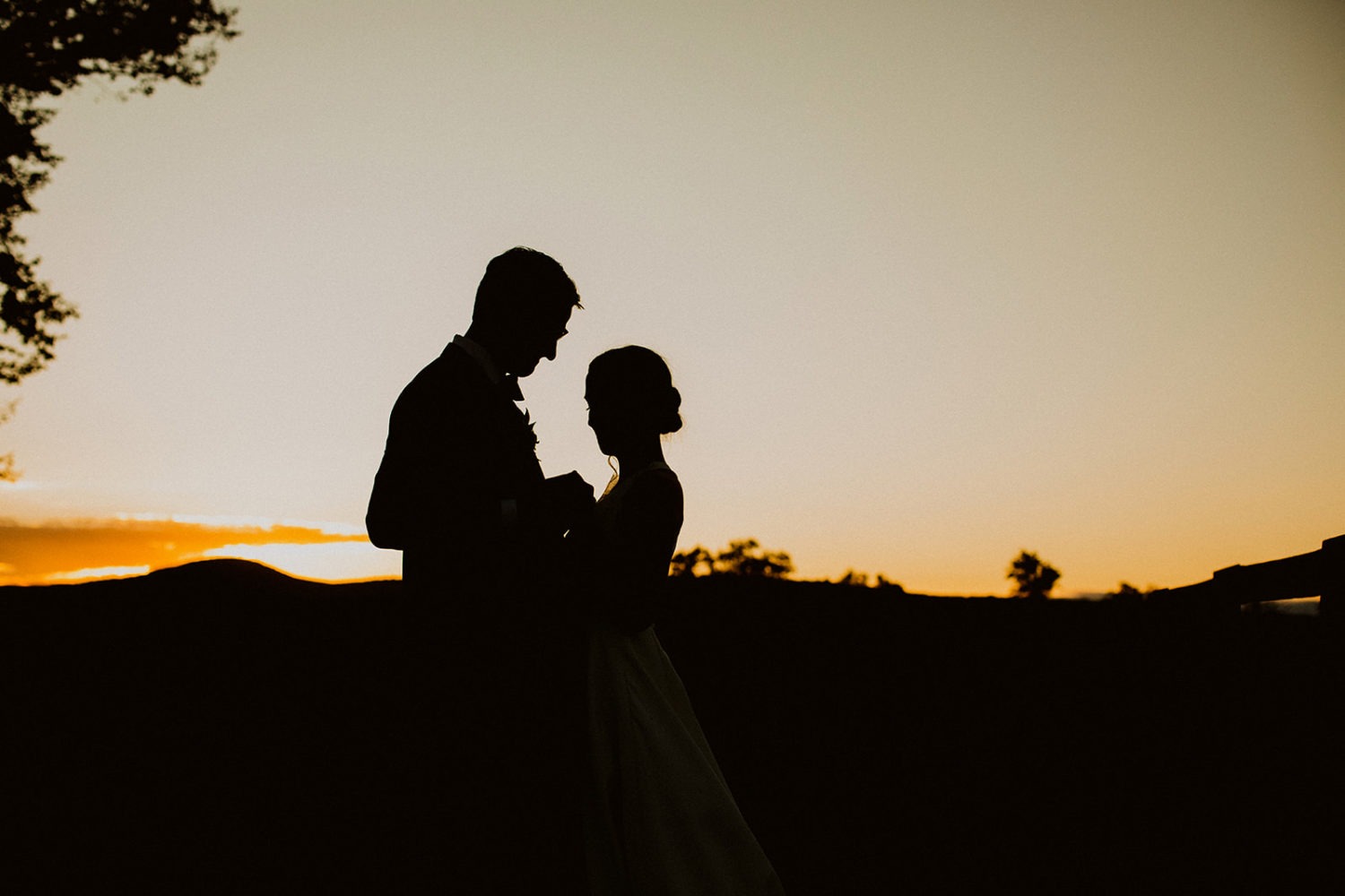 couple embraces in contrast to setting sun