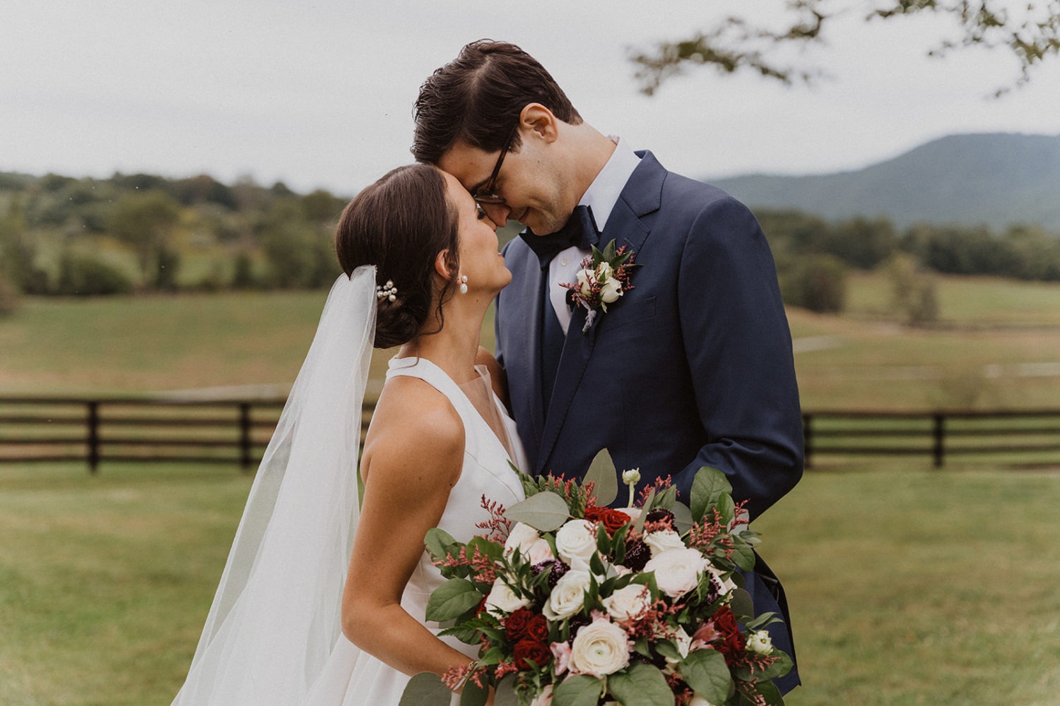 couple embraces while holding wedding bouquet at virginia wedding ranch venue