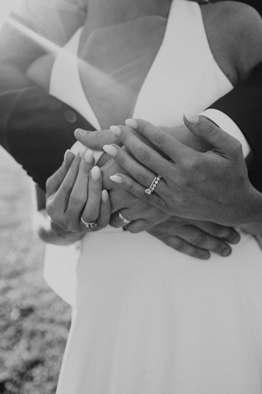 couple embraces holding hands and showing off wedding bands