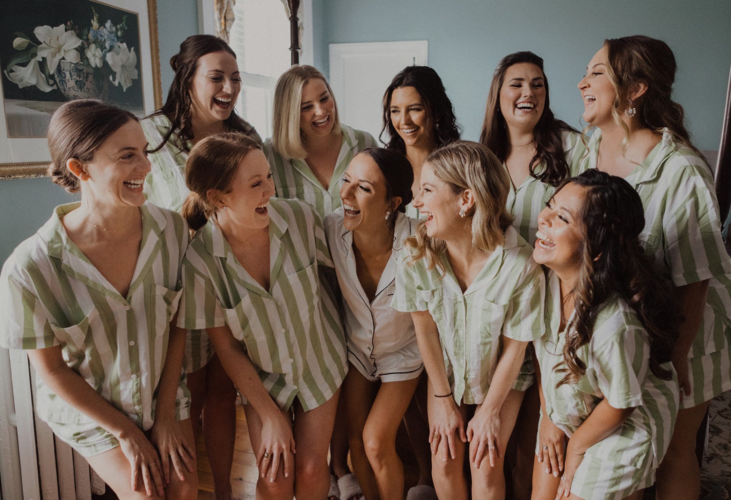 bride laughs with bridesmaids dressed in matching pajamas
