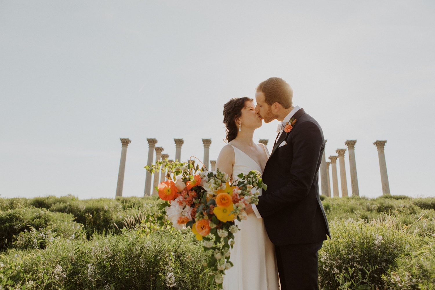 couple kisses in front of national columns at National Arboretum DC wedding