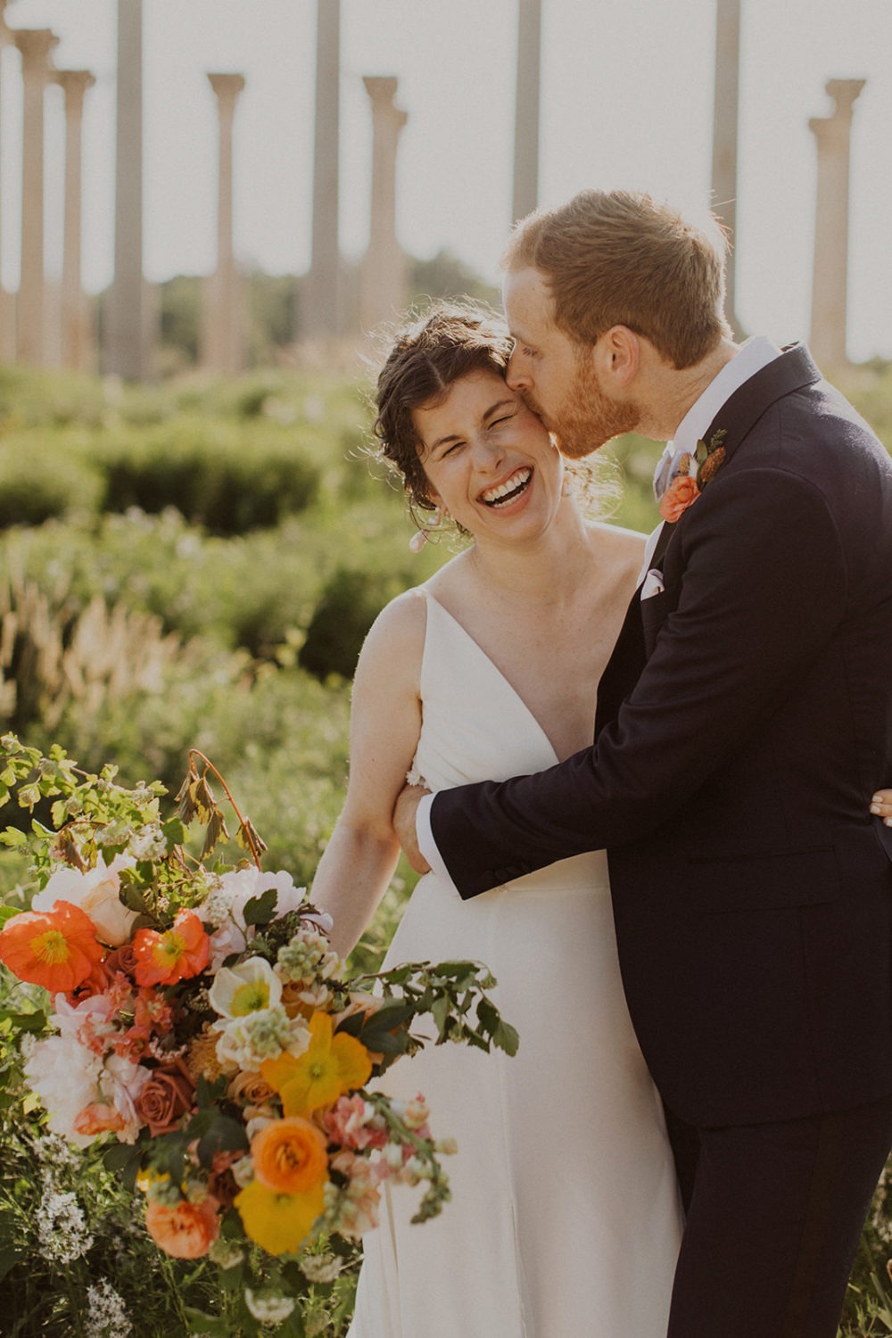 couple kisses in front of Capitol Columns at National Arboretum wedding