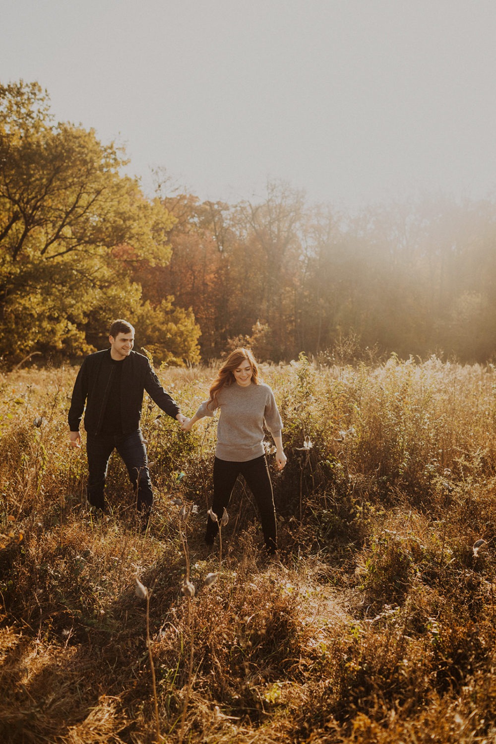 Couple walks through field holding hands at National Arboretum DC engagement session