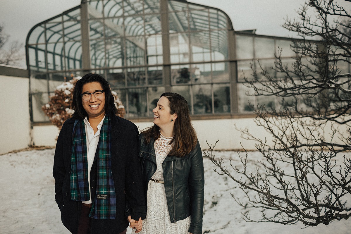 couple stands in snow outside of greenhouse at National Arboretum DC engagement session